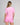 woman modelling back of pink short sleeve rashguard, featuring the BIG VIBES DAY logo on the back.