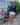 Woman wearing long sleeve navy AMOUR rashguard with hat, jewelery and shorts