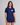 A woman modeling a navy blue short-sleeve rashgaurd and matching bashorts set. The rashgaurd features a small white heart on the left chest with the word AMOUR  in red text