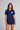 A woman modeling a navy blue short-sleeve rashgaurd and matching bashorts set. The rashgaurd features a small white heart on the left chest with the word AMOUR  in red text